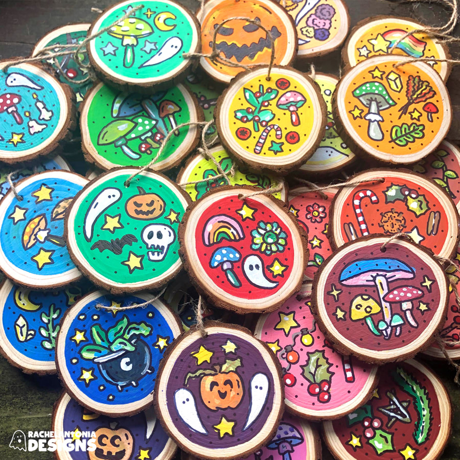 Photo of hand painted ornaments in a rainbow order with muhsrooms, jack o lanterns, ghosts and other designs hand painted on them